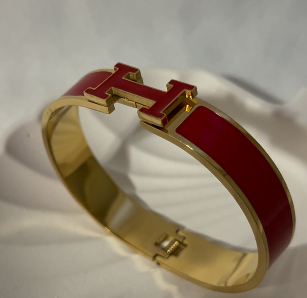 Red H bangle bracelet in polished gold tone, front view, luxury women’s enamel jewelry