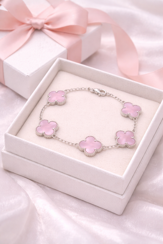 Pink flower bracelet in a white box with pink ribbons on a pink fabric background