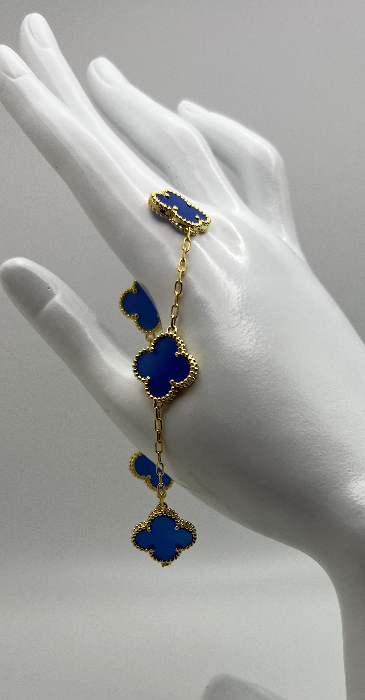 Blue floral bracelet on a mannequin hand against a gray background