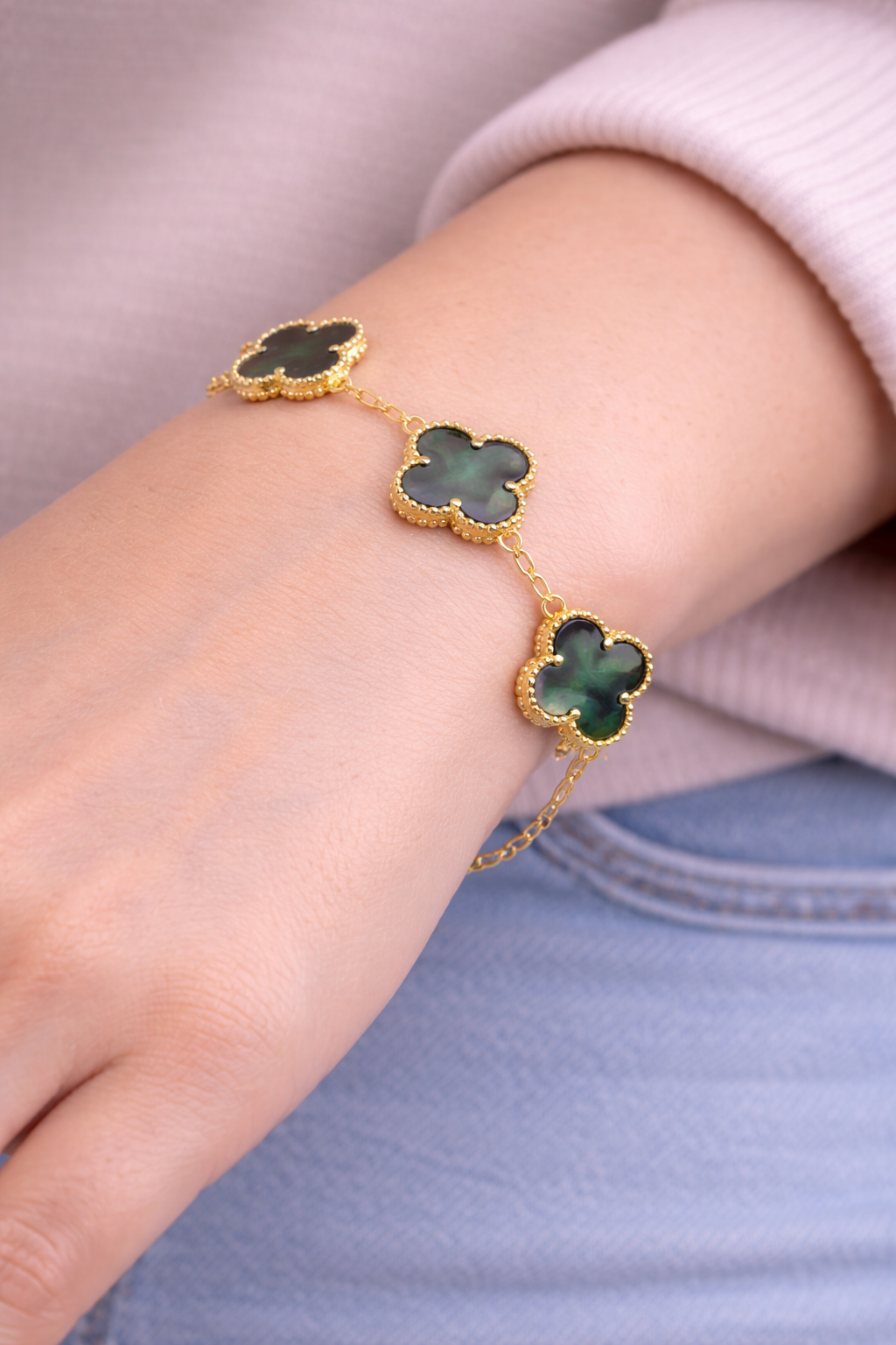 Gray mother of pearl clover bracelet worn on wrist, minimalist gold clover jewelry
