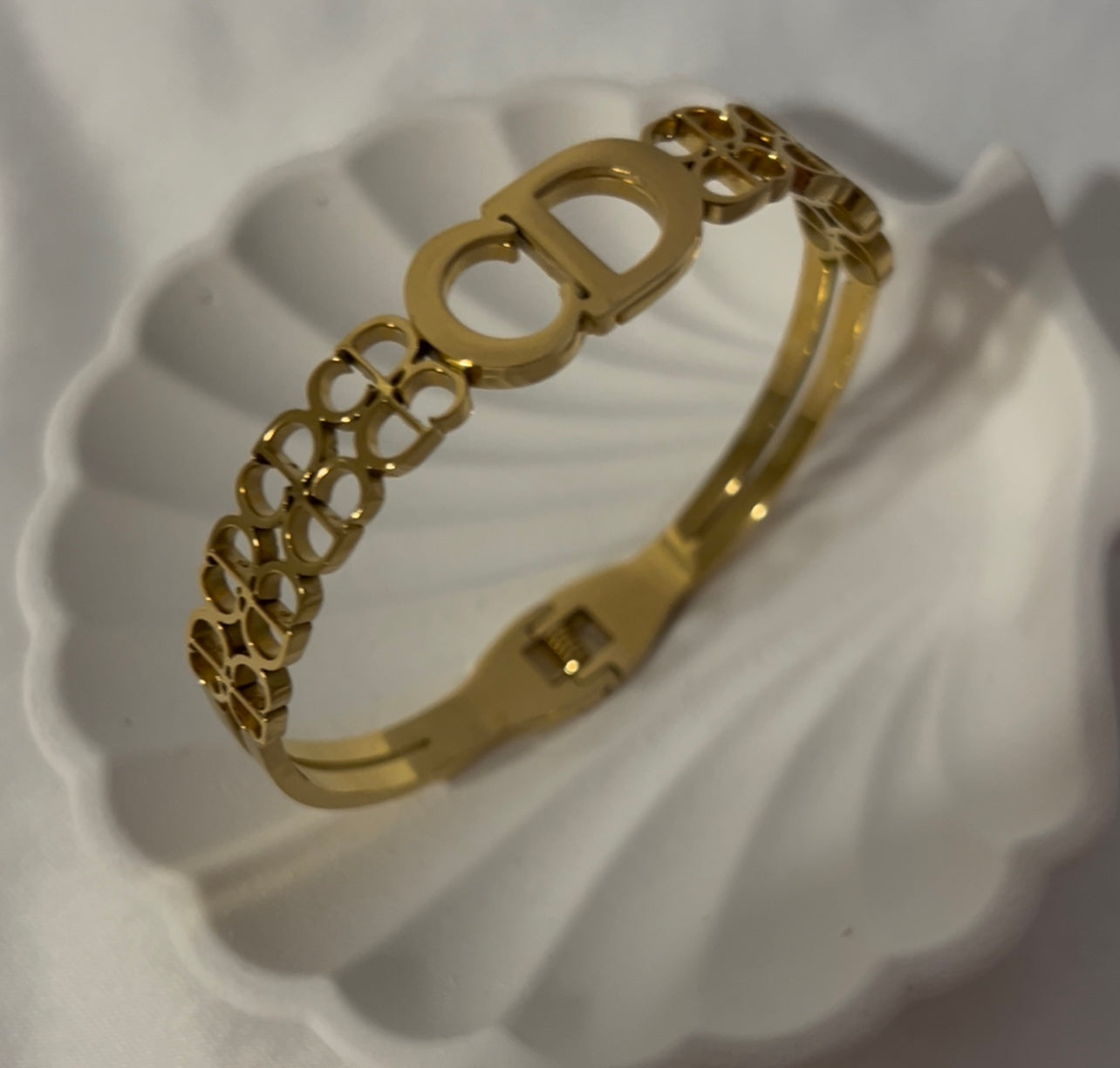 Gold tone letter-style bangle bracelet, front view, modern minimalist women’s jewelry with sleek enamel finish