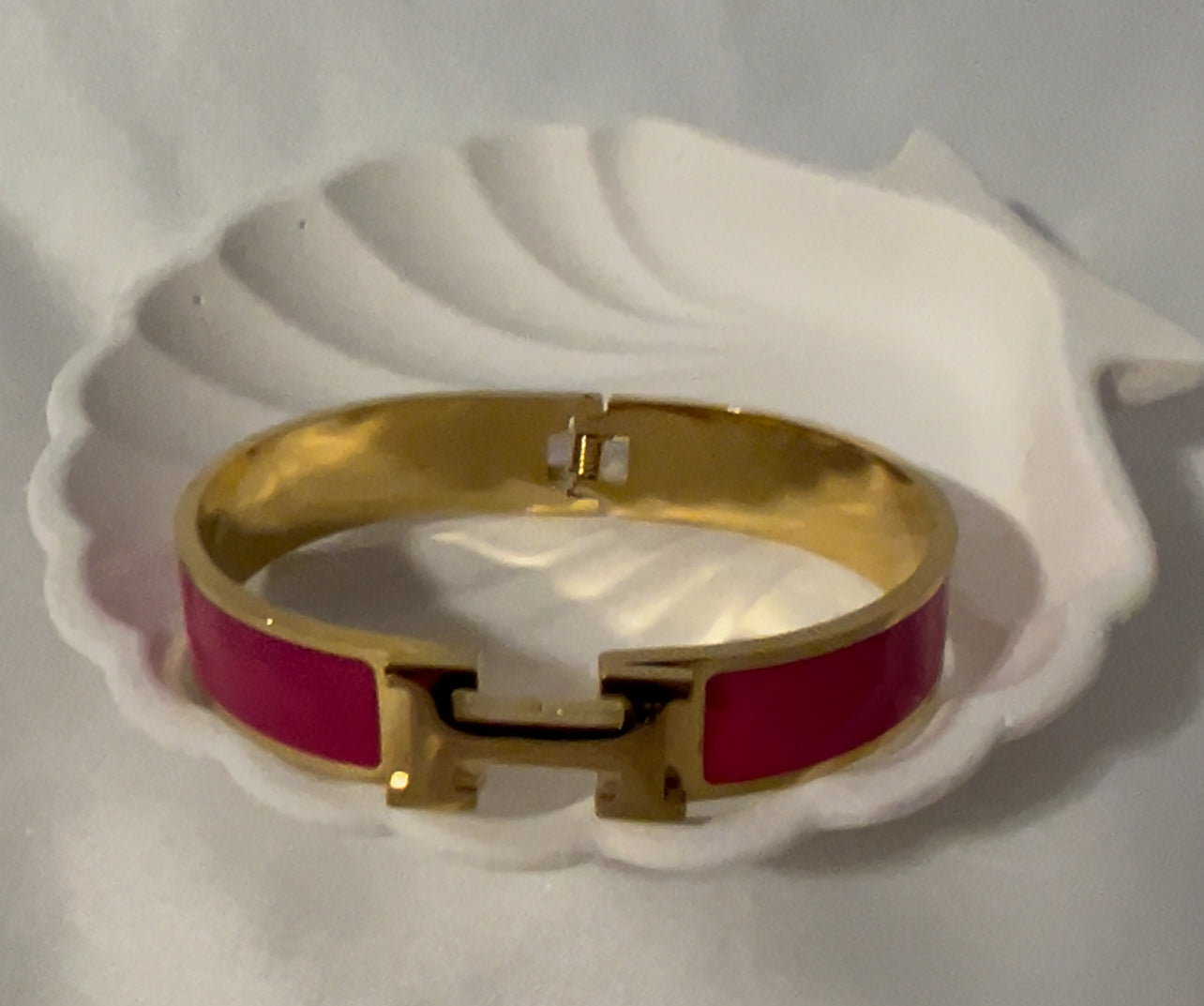 Close-up of magenta H bangle bracelet showing smooth enamel texture and premium gold plating